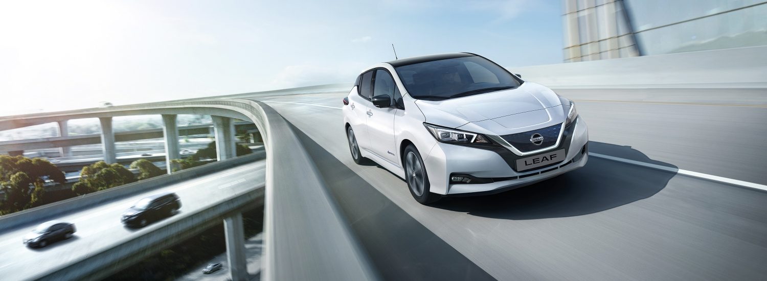 Nissan LEAF shown from the front driving on a highway overpass