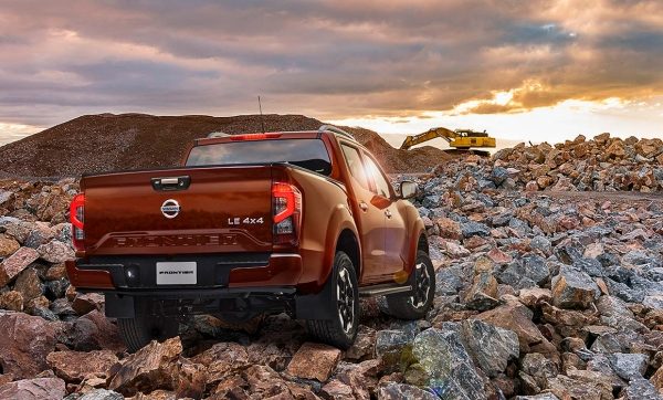 2021 Nissan Frontier showing person loading a trailer behind the vehicle