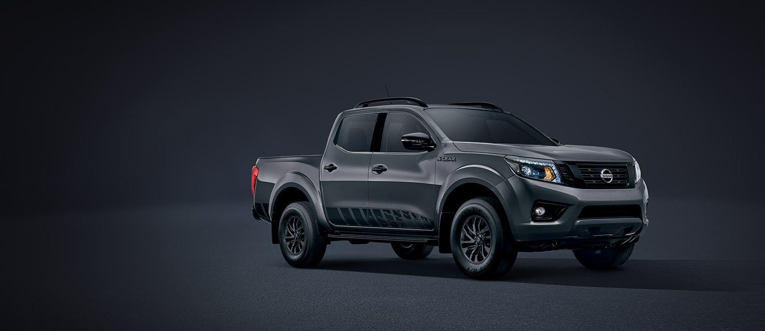 Nissan Frontier X-Gear levantado polvo junto a unas motocicletas