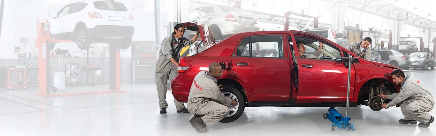 Equipo de mecánicos trabajando en un Nissan Versa