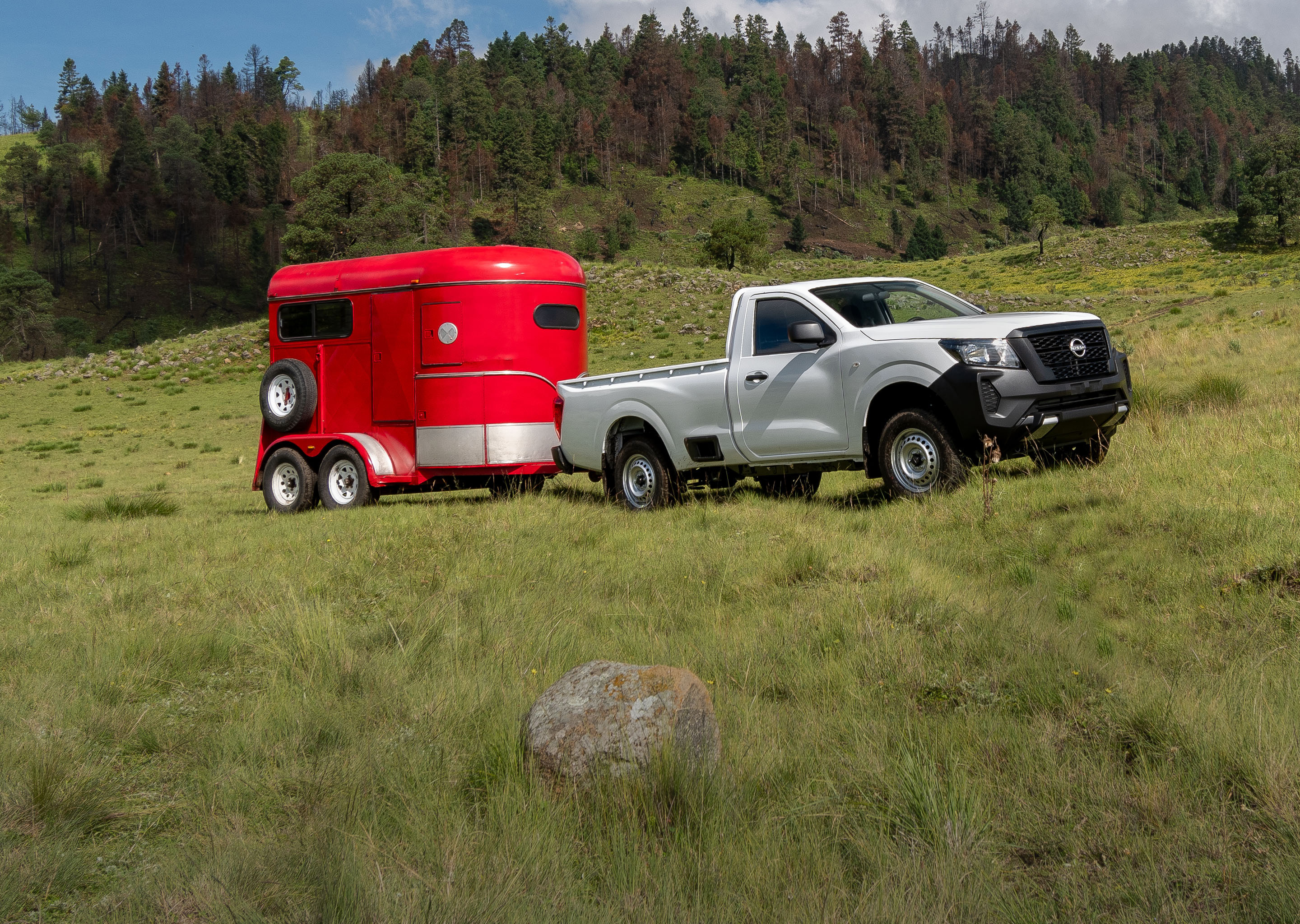 Vista frontal de Nissan blanca recorriendo el camino con potencia imparable