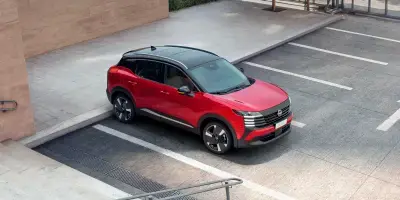 SUV Nissan Kicks vermelho com teto preto, visto de cima em ângulo diagonal.