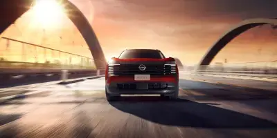 Nissan Kicks vermelho com teto preto em movimento por uma rua urbana, visto pelo ângulo traseiro direito com efeito de desfoque para indicar velocidade.
