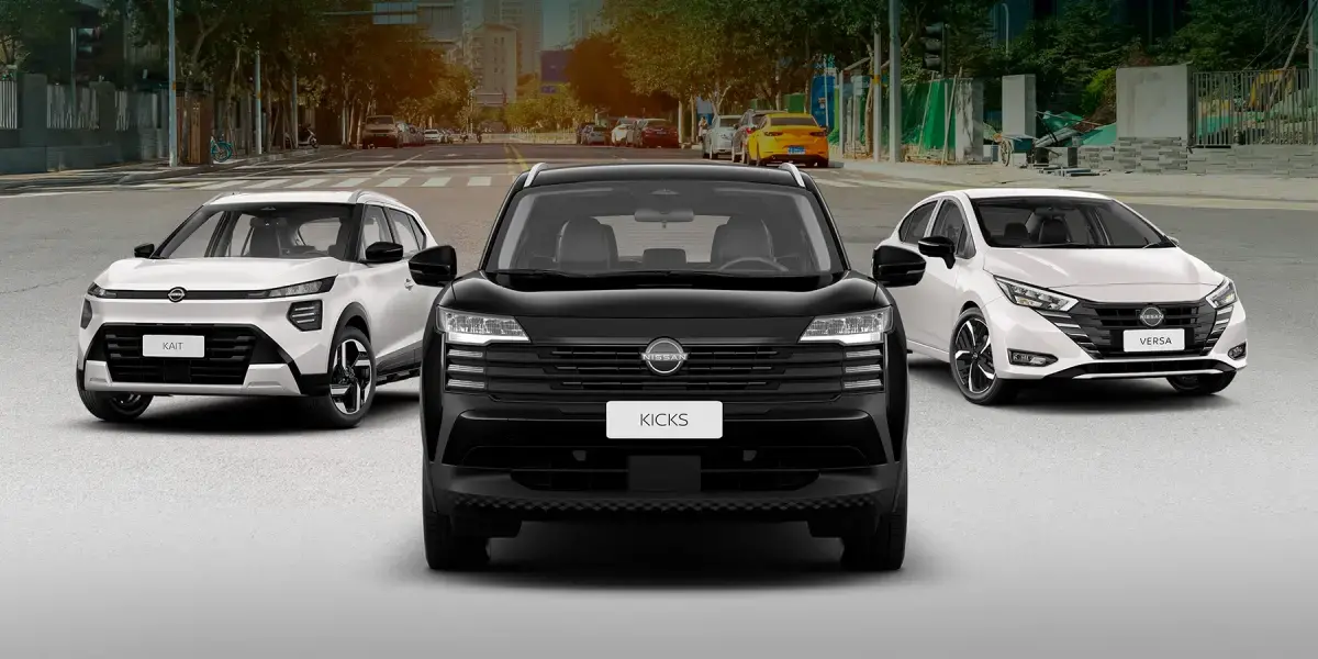 Três carros alinhados de frente em uma rua: Nissan Kicks preto ao centro, ladeado por dois modelos brancos.