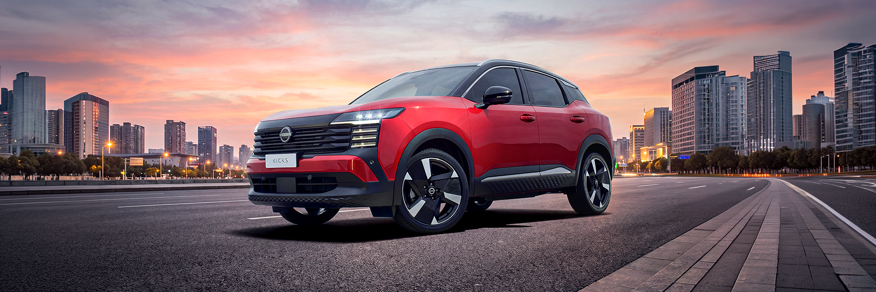 Parte lateral do novo Nissan Kicks vermelho 2027 em um cenário de cidade ao entardecer.