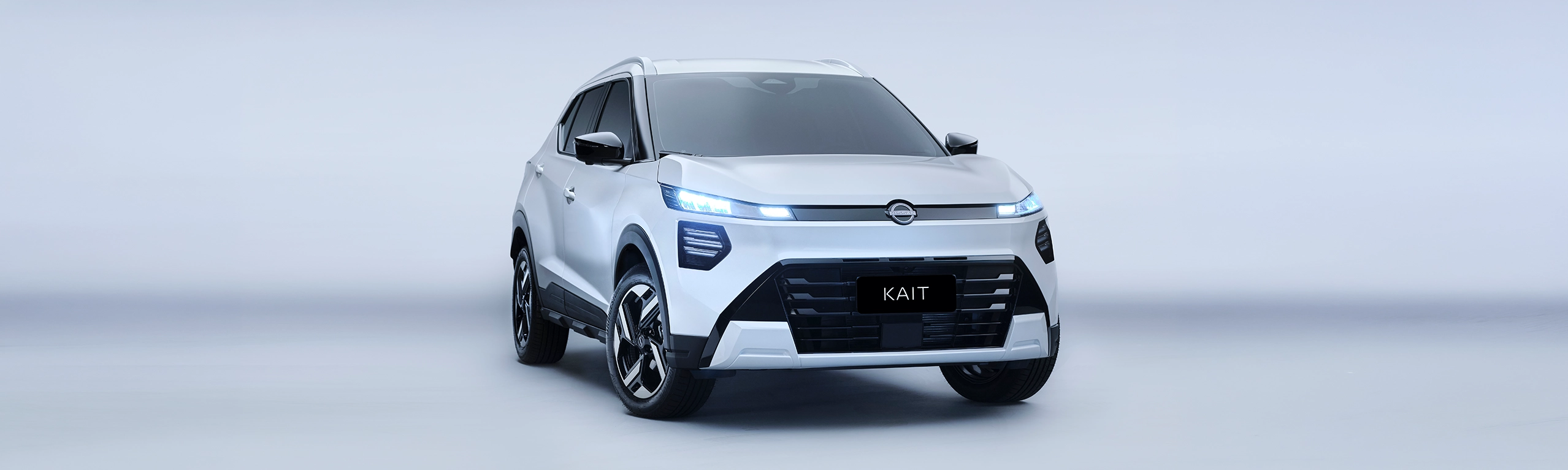 Veículo SUV branco estacionado em fundo neutro, com a palavra 'KAIT' na placa dianteira.