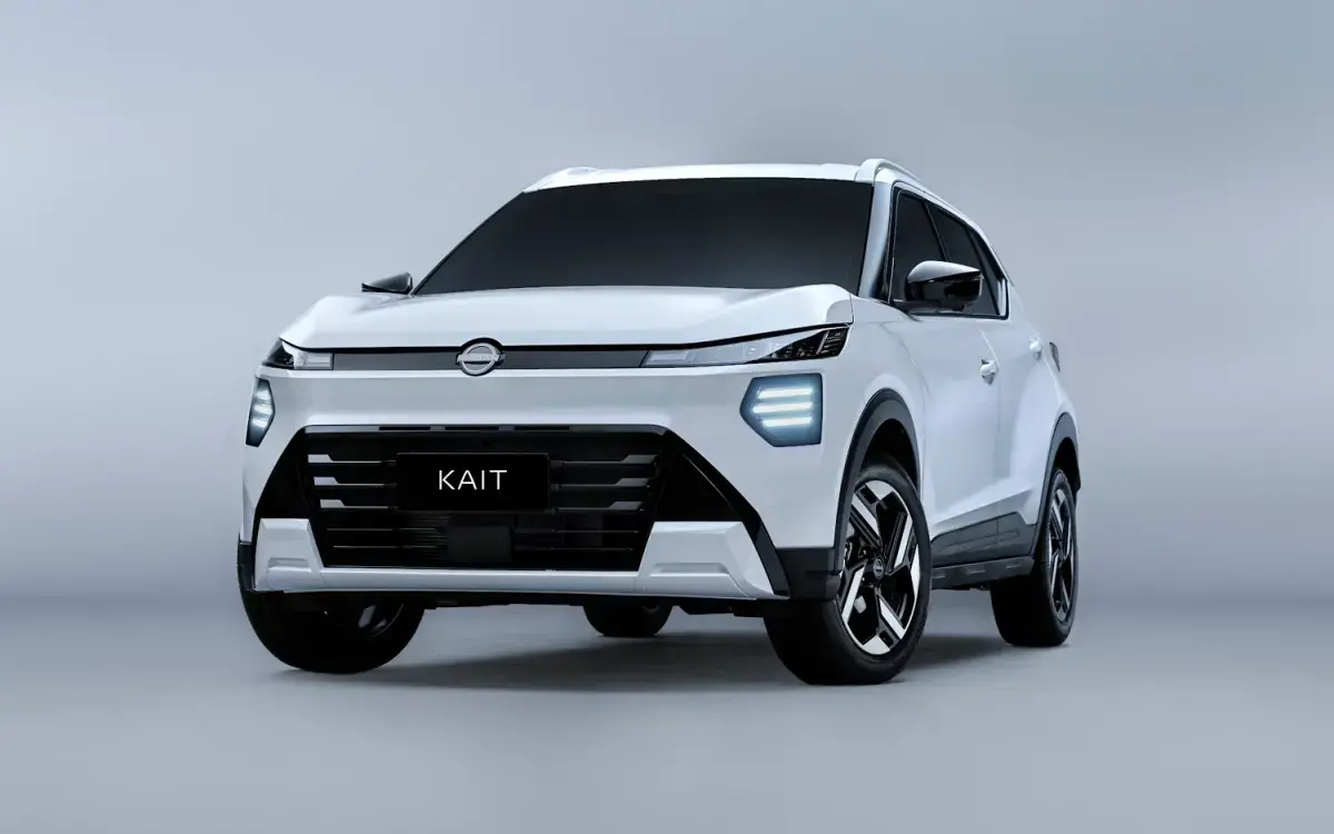 O Nissan Ariya elétrico na cor cobre com teto preto está parado em uma rua, com colunas de viaduto ao fundo. O design moderno e elegante do SUV elétrico destaca-se sob a luz do dia.