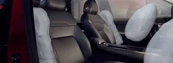 Interior de um carro simulando um impacto. Airbags laterais, de cortina e do volante estão inflados, demonstrando o sistema de segurança dos ocupantes.