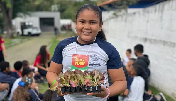 Crianças plantando mudas no projeto Escola Verde