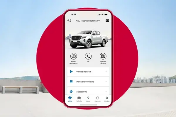 Smartphone com app "MEU NISSAN FRONTIER", exibindo picape branca e opções como "Videos How-to". Fundo vermelho circular e paisagem clara.