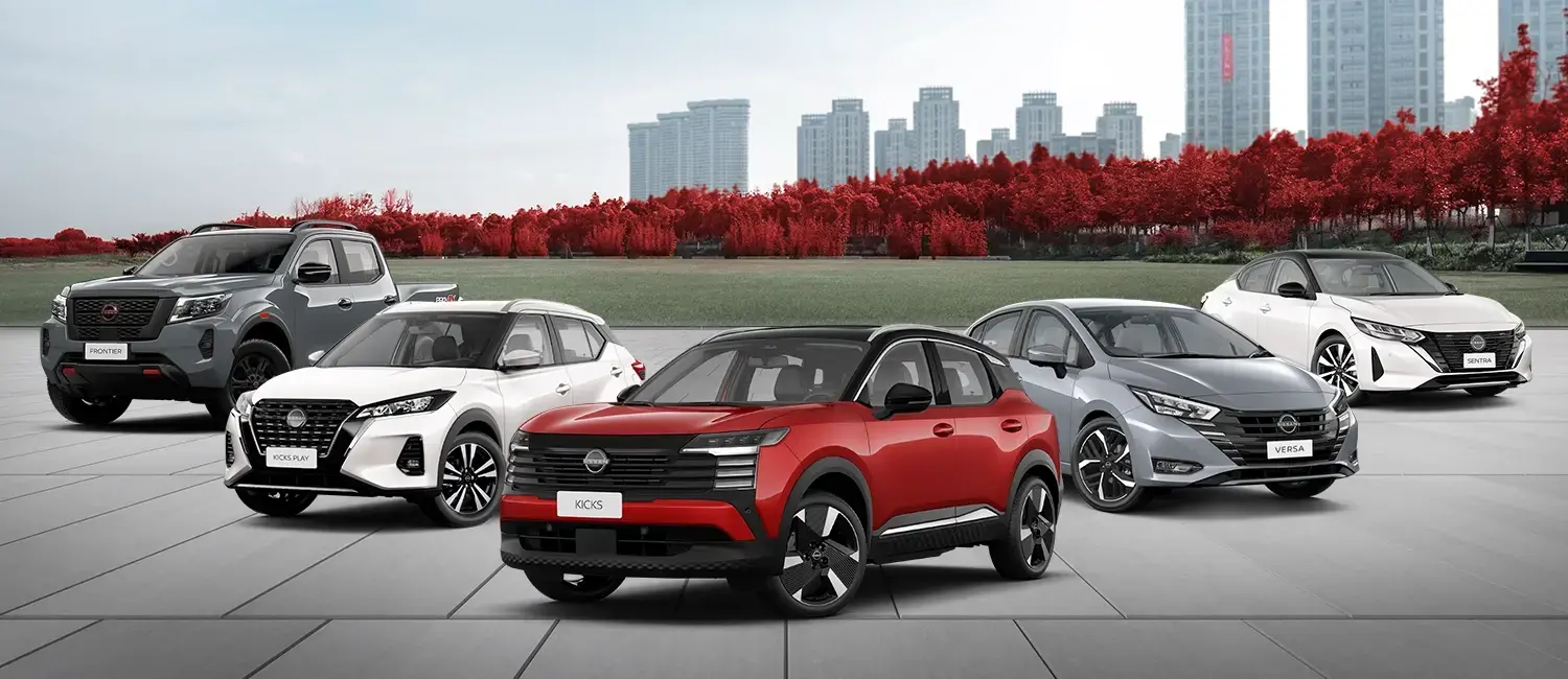 Linha de 5 veículos Nissan: picape Frontier cinza, Kicks Play branco, Kicks vermelho no centro, Versa cinza e Sentra branco. Fundo com cidade e árvores vermelhas.