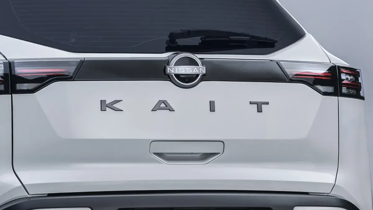 Close-up do emblema "KAIT" cromado e em relevo na tampa do porta-malas do SUV.