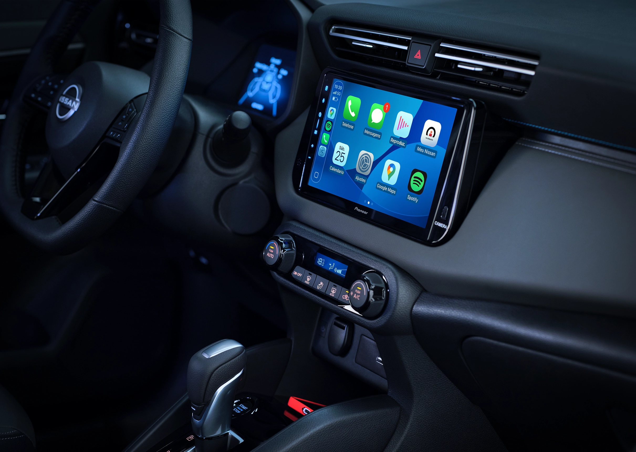Interior do Nissan KAIT com foco na tela multimídia central exibindo Apple CarPlay. O console inclui controles de ar e o seletor de marchas.