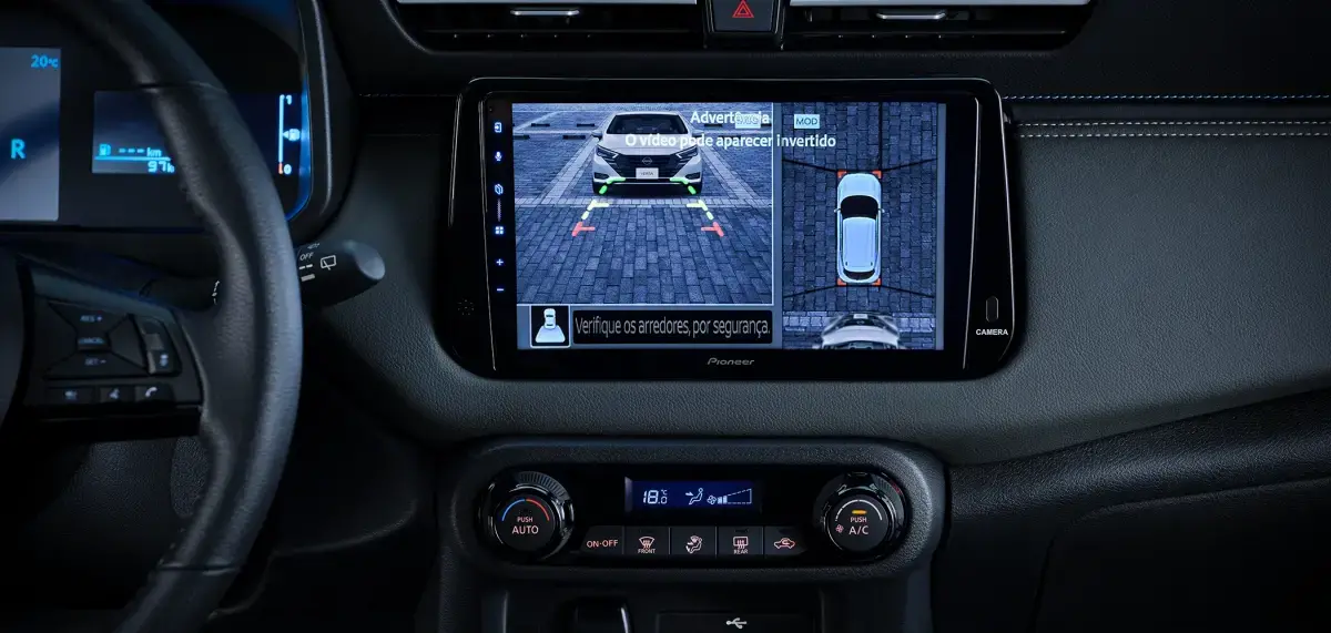 Interior do Nissan KAIT. Tela multimídia central exibe a visão 360 graus do veículo, mostrando o carro e seu entorno.
