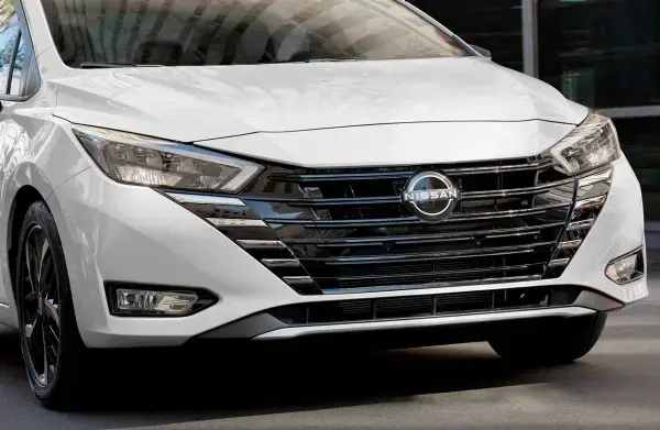 Detalhe da frente de um Nissan Versa, destacando a grade frontal e os faróis modernos, ideal para quem procura estilo e tecnologia.