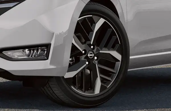 Detalhe da roda moderna e elegante, destacando o design sofisticado e as cores em preto e cromado de um veículo Nissan.