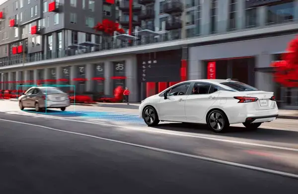 Dois carros em movimento em um ambiente urbano, destacando tecnologia avançada de assistência ao motorista.