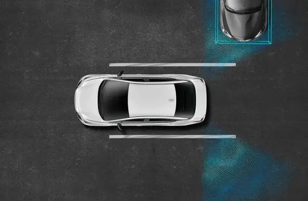 Visão superior de um carro Nissan cinza estacionando com auxílio de sensores. Destaca a tecnologia auxiliar para manobras seguras em espaços apertados.
