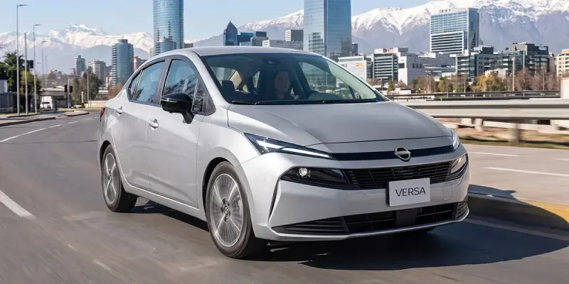 Rendimiento del Nissan Versa 2027 gris en el día a día, circulando por una avenida urbana.