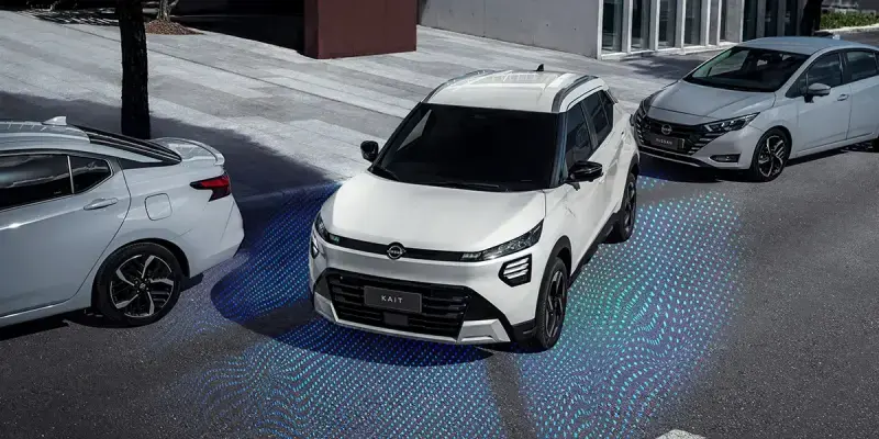 Nissan Kait con sensores de Nissan Intelligent Mobility visualizados en azul al maniobrar entre autos estacionados.