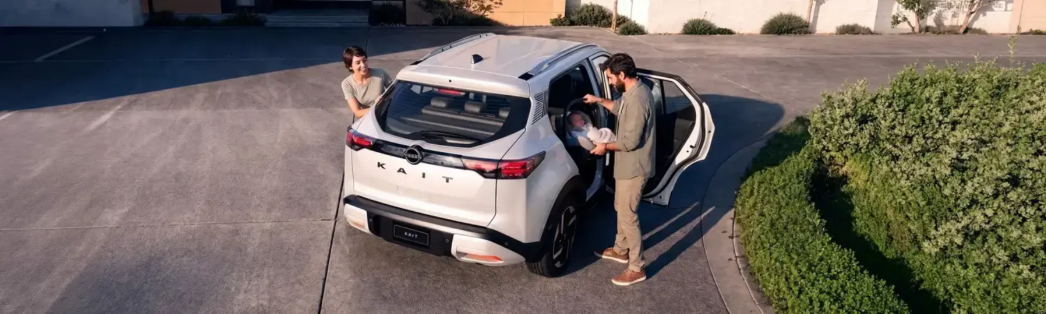 Pareja acomodando a su bebé en el Nissan Kait, un auto ideal para pareja con hijos.