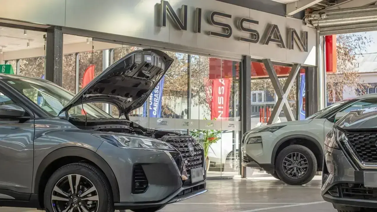 Vehículo Nissan con el capó abierto en un taller de servicio para su revisión de mantenimiento