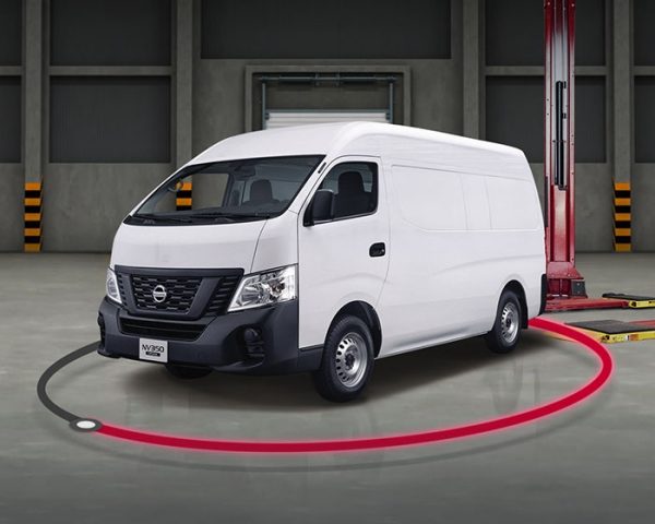 Vista frontal 3/4 de Nissan URVAN color blanco saliendo de rampa de servicio.