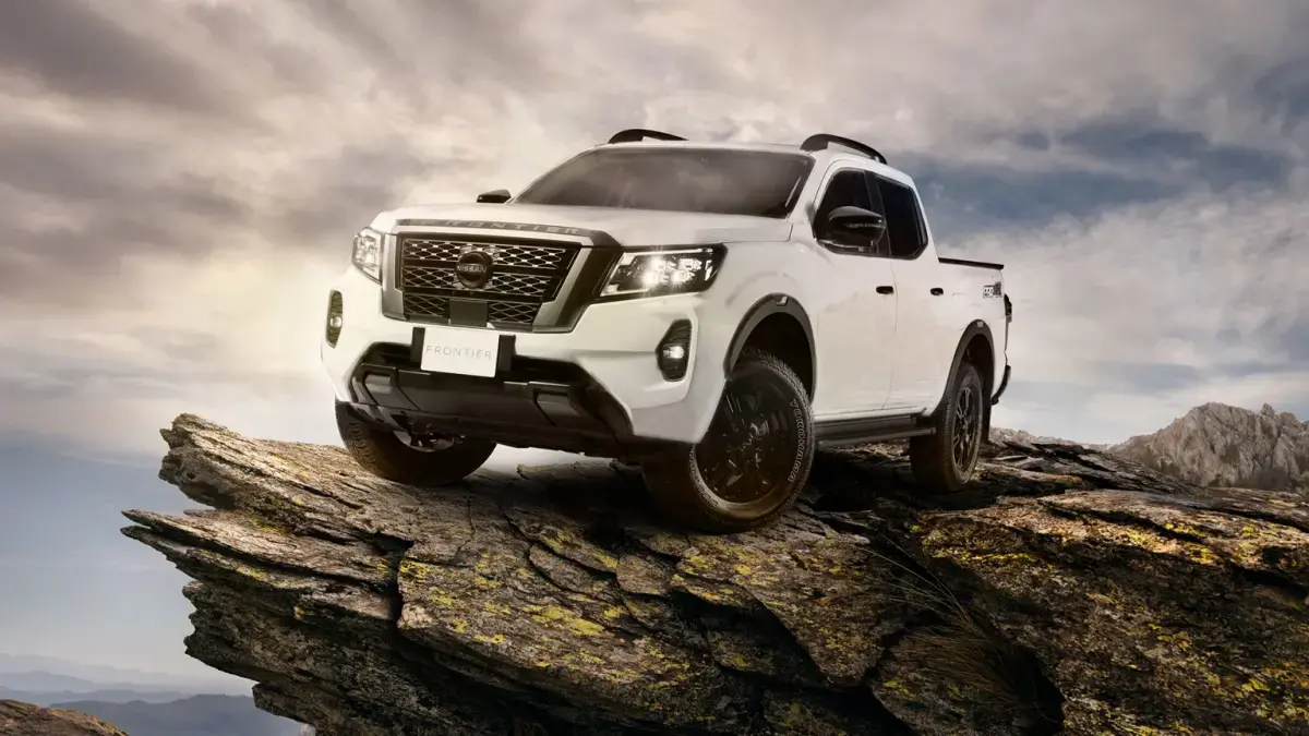 Vista frontal de Nissan NP300 blanca recorriendo el camino con potencia imparable