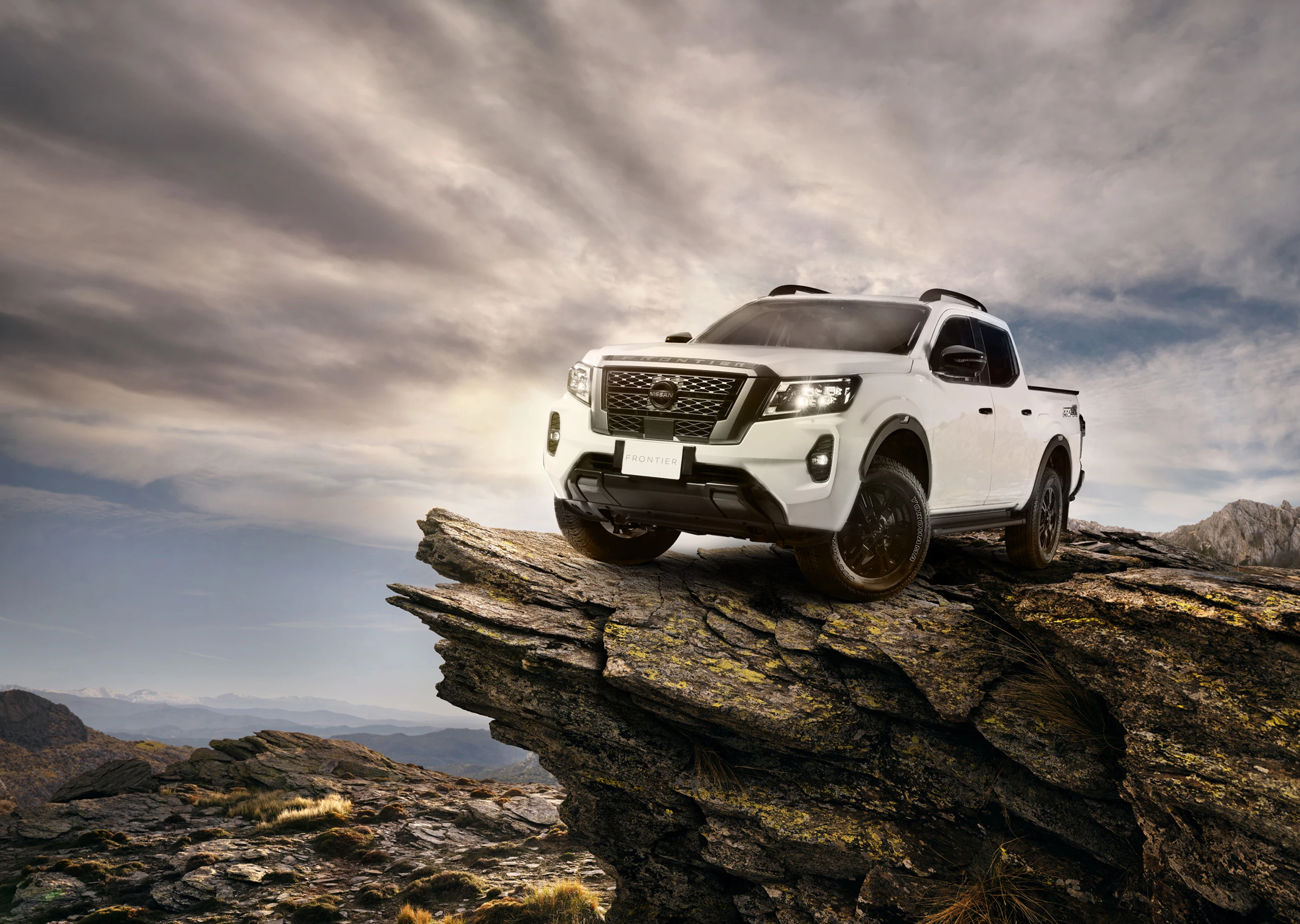 Vista tres cuartos frontal de Nissan NP300 alejándose de la puesta de sol