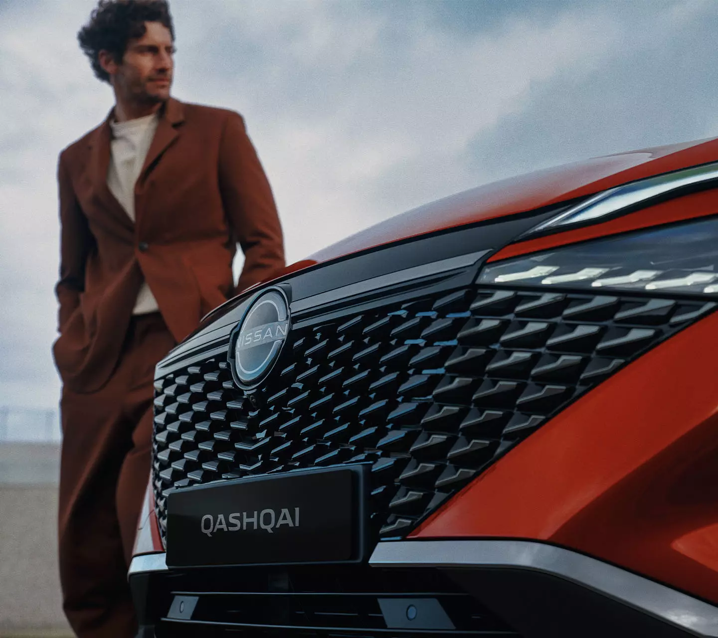 Front of Nissan Qashqai with man beside