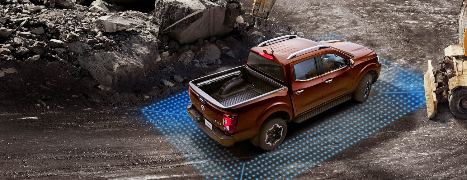 2021 Nissan Frontier showing intelligent cruise control sensors while driving over a bridge