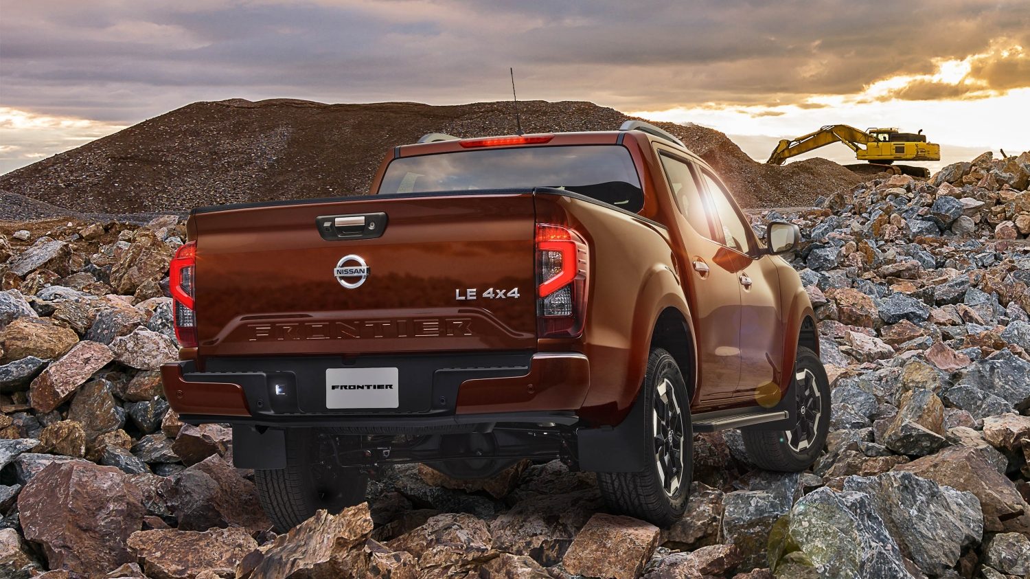 2021 Nissan Frontier driving over bridge at sunset