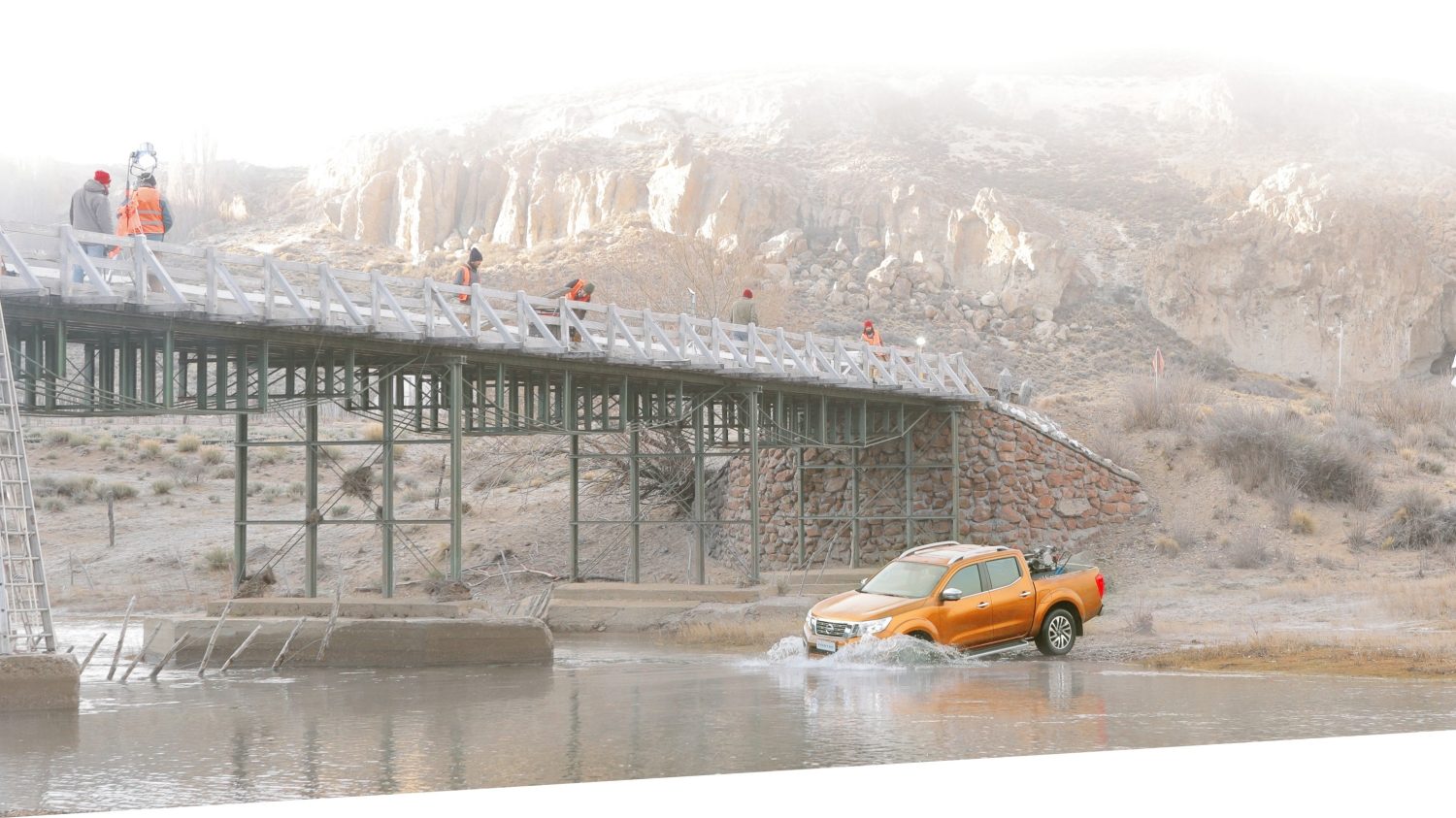 Frontier descendiendo en un lago y puente con trabajadores