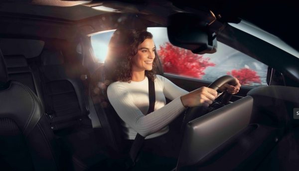 Mujer conduciendo un vehículo eléctrico Nissan