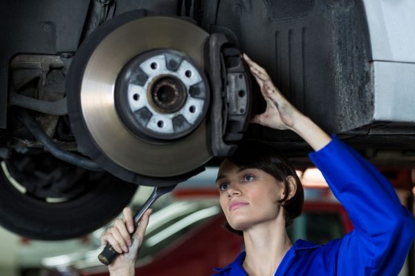 Persona revisando los frenos de un vehículo
