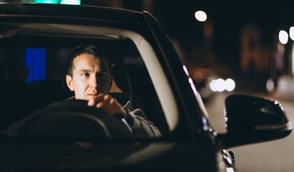 Hombre manejando un vehículo de noche