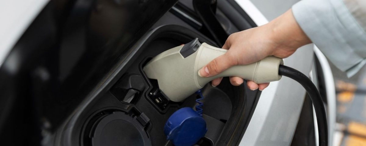 Persona cargando su auto eléctrico